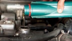 Car mechanic changing engine oil